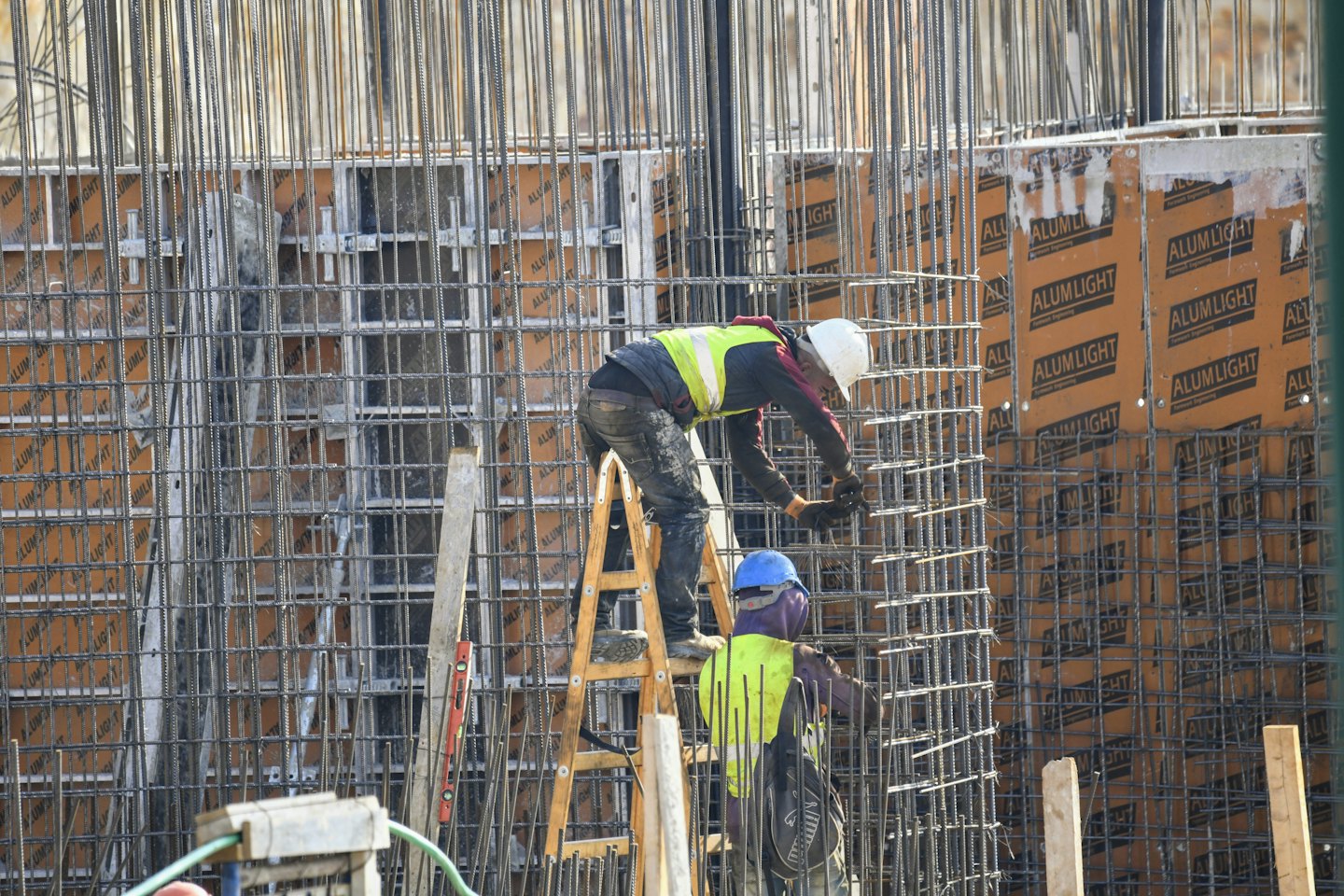 Bauarbeiter errichten Stahlbewehrungsrahmen auf der Baustelle.
